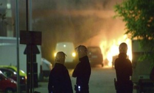 ESTOCOLMO, Suecia.- Bomberos suecos observan un vehículo en llamas durante los disturbios ocurridos en Estocolmo. (Foto: EFE)