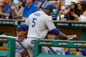 El dominicano Juan Uribe, de los Dodgers de Los Angeles, es felicitado en el dugout después de anotar contra los Piratas de Pittsburgh (AP ) 