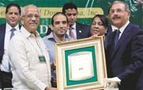 El presidente del Consejo de Directores de la JAD, César Paniagua, entrega una placa de reconocimiento al presidente Danilo Medina.