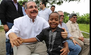 El presidente Danilo Medina se entretiene con un niño ayer en el municipio Quisqueya, de San Pedro de Macorís, donde aprobó la construcción de una nave industrial para un proyecto de mujeres.