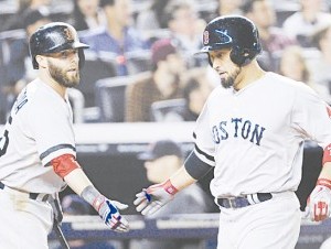 Shane Victorino, izquierda, es felicitado por Dustin Pedroia luego de anotar una carrera en el quinto episoidio. (AP ) 