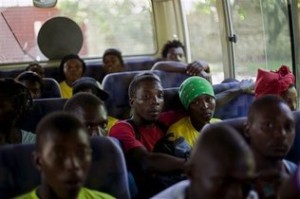 Decenas de haitianos aguardan sentados en un autobús antes de ser trasladados a sus poblados de origen desde un refugio en Croix-des-Bouquets, Haití, después de ser deportados por Dominicana el domingo este domingo