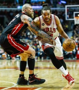 El centro de los Bulls de Chicago Joakim Noah maneja el balón en ruta al canasto frente a la defensa de Chris Andersen, de los Heat de Miami, en la segunda mitad del partido de ayer en la NBA celebrado en el United Center de Chicago, Illinois.