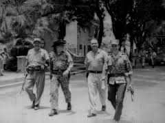 El coronel Francisco Alberto Caamaño, acompañado de Manuel Montes Arache, Gerardo Marte y Claudio Caamaño caminan por una calle de la ciudad durante el desarrollo de la Revolución de Abril de 1965.