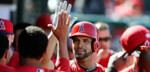 El inicialista Albert Pujols recibe el saludo de sus compañeros al llegar a la cueva de los Angelinos, luego de que el toletero dominicano conectara su cuarto cuadrangular de la temporada y el 496 de su brillante carrera. AP.