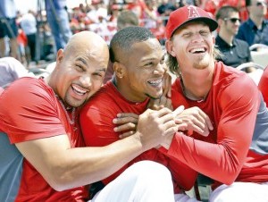 Erick Aybar (centro) bromea con sus compañeros Albert Pujols (izquierda) y Jered Weaver. (AP ) .