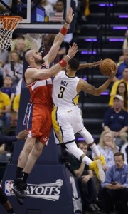 Marcin Gortat, de los Wizards, intenta bloquear un intento al canasto de George Hill, de los Pacers, en la primera mitad del partido de ayer enla semifinal de la Conferencia del Este en los playoffs de la NBA.