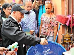 El ministro de Salud Pública, Freddy Hidalgo, limpia un tanque en Cristo Rey, en el Distrito Nacional. 