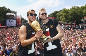 Los jugadores alemanes, Mario Goetze (izquierda), y Andre Schuerrle (derecha), celebran encima delescenario su victoria en una ceremonia en Berlín, Alemania, este martes.