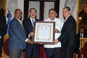 El presidente Medina entrega el premio a Juan Bolívar Díaz, junto al ministro de Educación, Carlos Amarante Baret, y el presidente del CDP, Olivo de León.