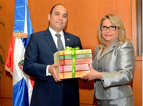 El administrador general de Banreservas, Enrique Ramírez Paniagua, entrega los libros a la embajadora dominicana en Francia, Rosa Hernández de Grullón