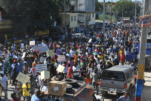 HAI106. PUERTO PRÍNCIPE (HAITÍ), 18/12/2014.- Opositores haitianos marchan para exigir la renuncia del presidente del país, Michel Martelly, hoy jueves 18 de diciembre del 2014, en Puerto Príncipe (Haití). Los manifestantes recorrieron por durante horas las calles de Puerto Príncipe en dirección al emblemático parque "Champ de Mars", situado frente al Palacio Nacional. En los barrios Delmas 60 y 87 de la capital, individuos no identificados arrojaron piedras contra los protestantes, lo que provocó que la Policía haitiana que acompañaba la manifestación respondiera con gases lacrimógenos y la dispersara. EFE/Jean Jacques Augustin