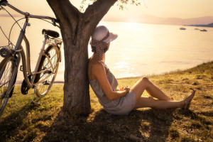 Mujer-solitaria-sentada-en-el-suelo-mirando-al-lago