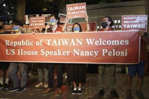 Simpatizantes de Nancy Pelosi sostienen carteles de bienvenida a la presidenta frente al hotel donde se hospedará, este martes.CHIANGYING-YING (AP)